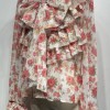 Αέρινη μπλούζα με ρομαντικό floral print σε αποχρώσεις ροζ, διακοσμημένη με εντυπωσιακά βολάν και φιόγκο μπροστά. Διαθέτει ιδιαίτερες λεπτομέρειες στον γιακά με τριαντάφυλλα και μακριά μανίκια με βολάν στο τελείωμα
